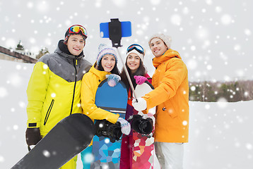 Image showing happy friends with snowboards and smartphone