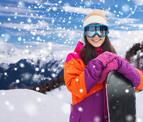 Image showing happy young woman with snowboard over mountains