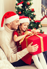 Image showing smiling father and daughter opening gift box