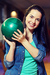 Image showing happy young woman holding ball in bowling club