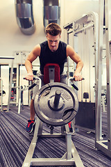 Image showing young man exercising on t-bar row machine in gym