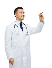 Image showing smiling male doctor writing something with marker