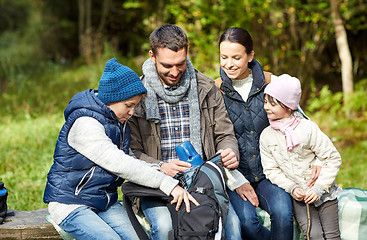 Image showing happy family with backpack and thermos at camp