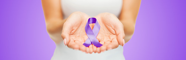 Image showing close up of hands holding purple awareness ribbon