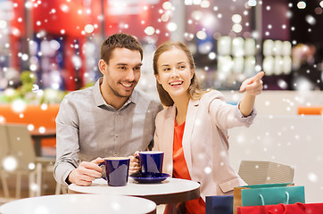 Image showing happy couple with shopping bags drinking coffee