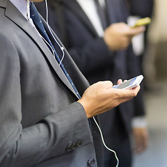 Image showing Businessmen using their cell phones on subway.