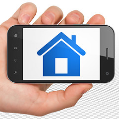 Image showing Business concept: Hand Holding Smartphone with Home on display