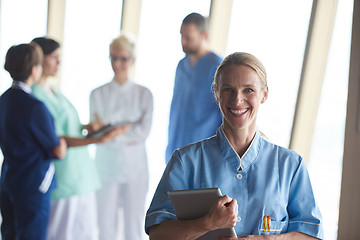 Image showing female doctor with tablet computer  standing in front of team