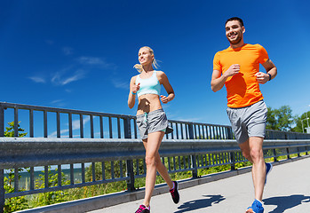 Image showing smiling couple running at summer seaside