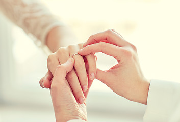 Image showing close up of lesbian couple hands with wedding ring