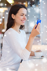 Image showing smiling woman with smartphone and coffee at cafe