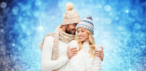 Image showing happy couple in winter clothes hugging over lights