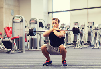 Image showing young man flexing muscles with barbell in gym