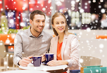 Image showing happy couple with shopping bags drinking coffee