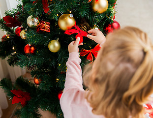 Image showing close up of child decorating christmas tree