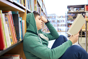 Image showing student boy or young man reading book in library