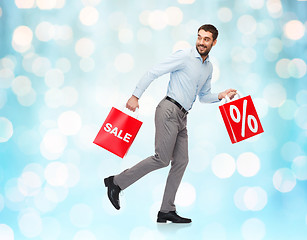 Image showing smiling man with red shopping bag