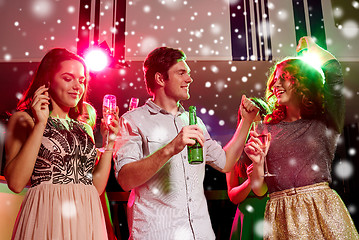 Image showing smiling friends with wine glasses and beer in club