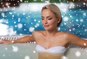 Image showing happy woman sitting in jacuzzi at poolside