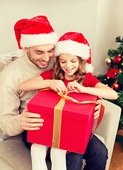 Image showing smiling father and daughter opening gift box