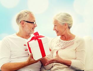 Image showing happy senior couple with gift box at home