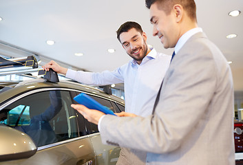 Image showing happy man with car dealer in auto show or salon