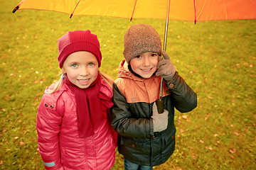 Image showing happy boy and girl with umbrella in autumn park