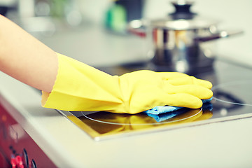 Image showing close up of woman cleaning cooker at home kitchen