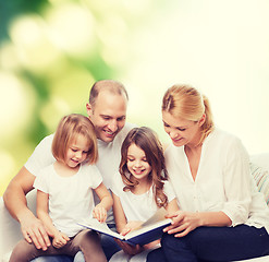 Image showing happy family with book at home