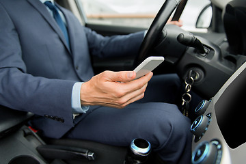 Image showing close up of man with smartphone driving car