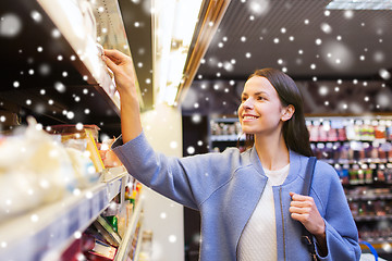 Image showing happy woman choosing and buying food in market