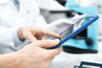 Image showing close up of scientists hands with tablet pc in lab