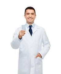 Image showing smiling male doctor in white coat with tablets