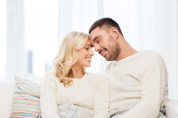 Image showing happy couple covered with plaid on sofa at home