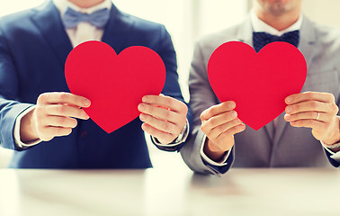 Image showing close up of male gay couple holding red hearts