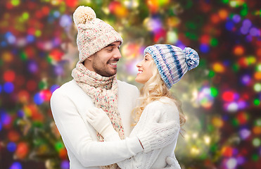 Image showing happy couple in winter clothes hugging over lights