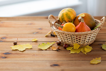 Image showing close up of pumpkins in basket on wooden table