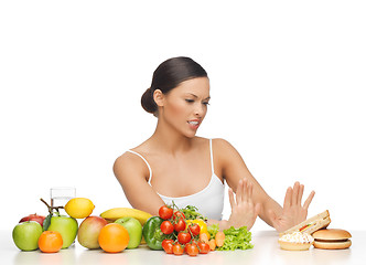 Image showing woman with fruits rejecting hamburger