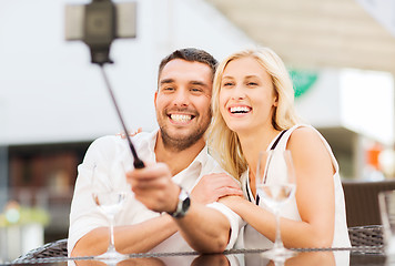 Image showing happy couple taking selfie with smartphone at cafe