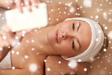 Image showing close up of smiling woman with smartphone in spa