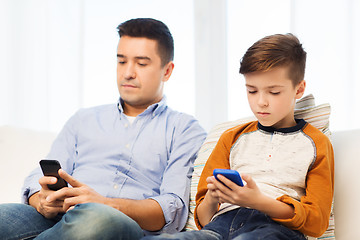 Image showing father and son with smartphones at home