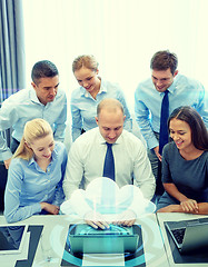 Image showing smiling business people with laptop in office