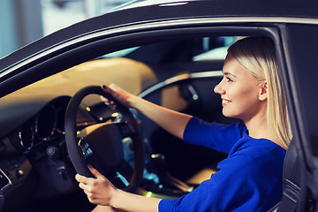 Image showing happy woman inside car in auto show or salon