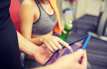 Image showing close up of trainer hands with tablet pc in gym