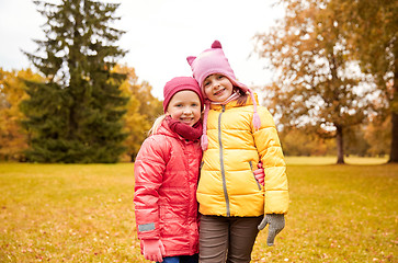 Image showing two happy little girls hugging in autumn park