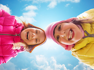 Image showing happy little girls faces over blue sky