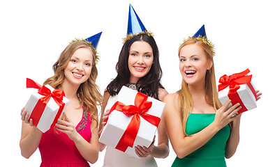 Image showing three smiling women in blue hats with gift boxes