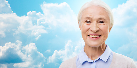 Image showing happy senior woman face over blue sky and clouds