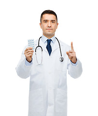 Image showing male doctor in white coat with tablets