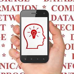 Image showing Information concept: Hand Holding Smartphone with Head With Lightbulb on display